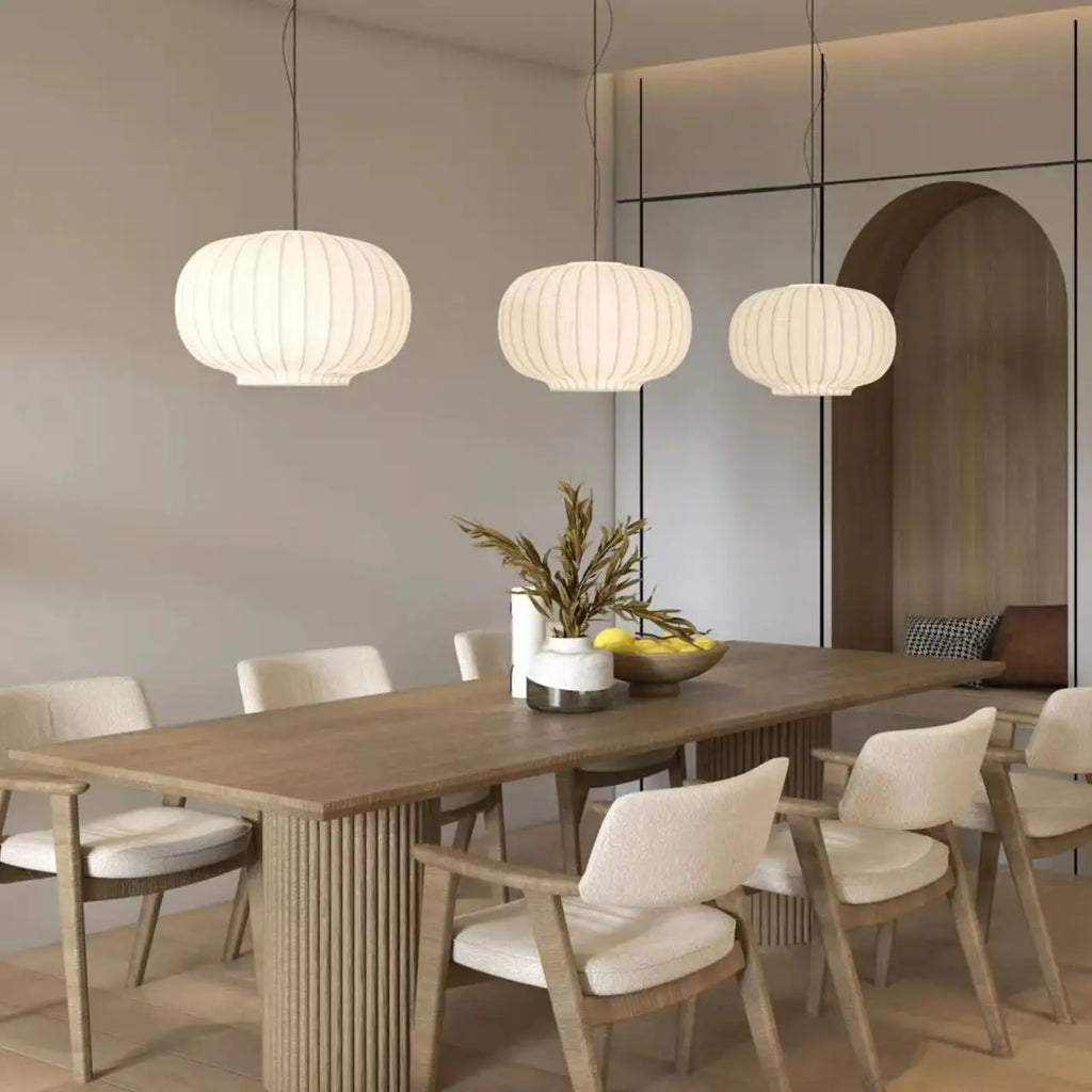 Three Danish-style silk pendant lights hanging above a dining table in a modern interior