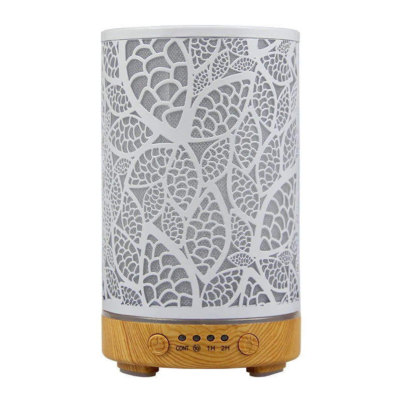 Leaf pattern aromatherapy diffuser with white finish and light wood grain base.