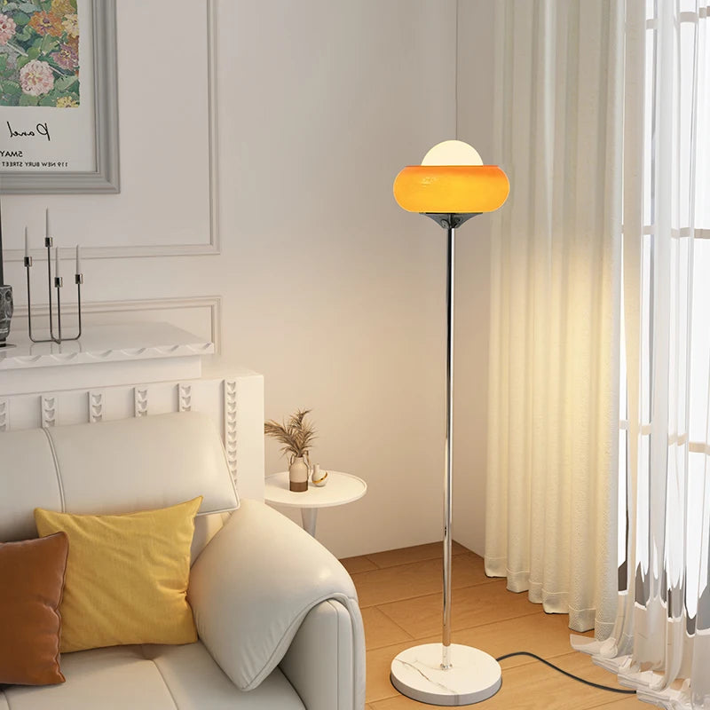 Modern floor lamp with a yellow shade in a living room setting.