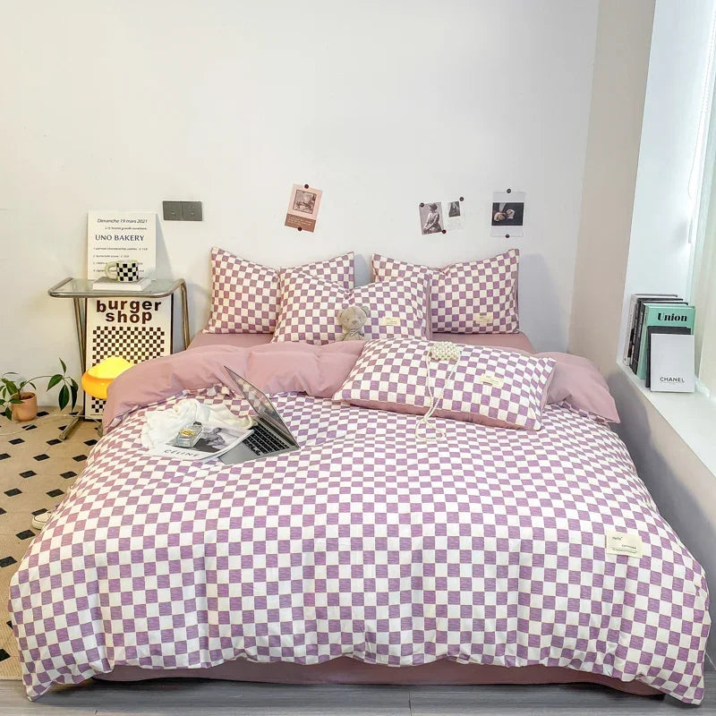 Lilac and white checkerboard duvet cover set with matching pillowcases dressed on a double bed in a modern styled bedroom