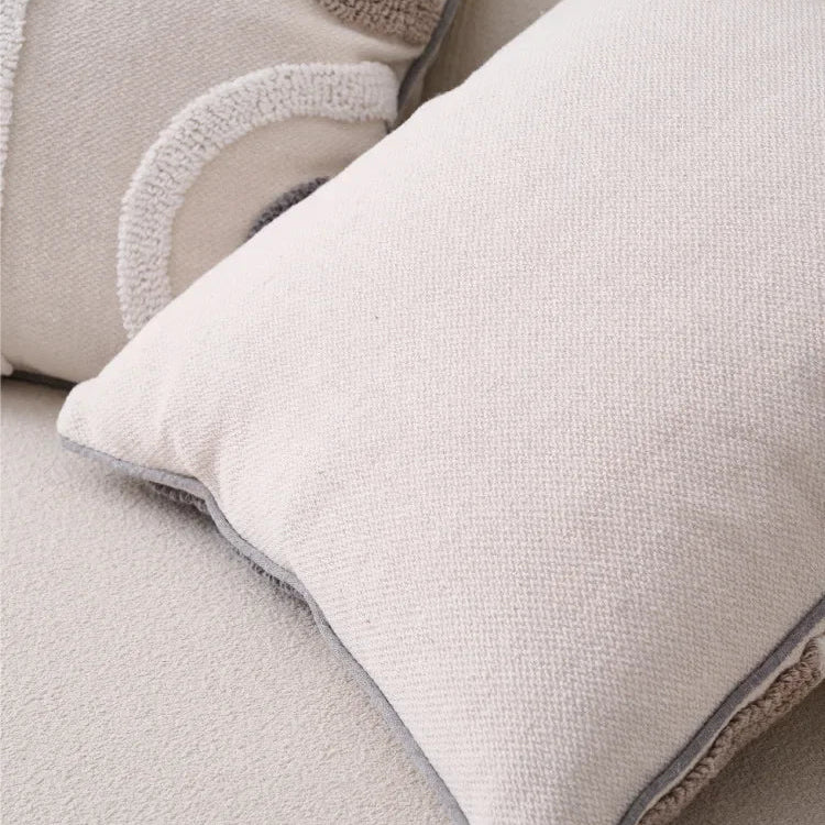 Close-up of a textured beige pillow on a sofa with a neutral background