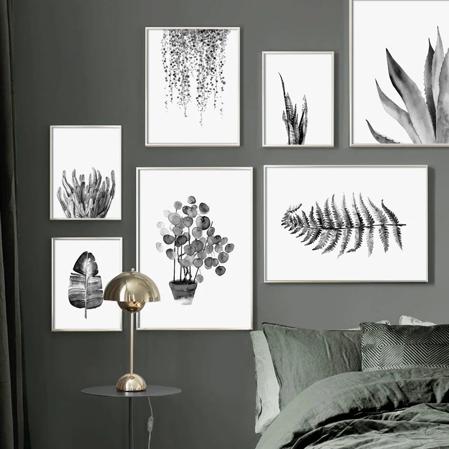 Wall art prints of plants and abstract designs on a gray wall above a bed.