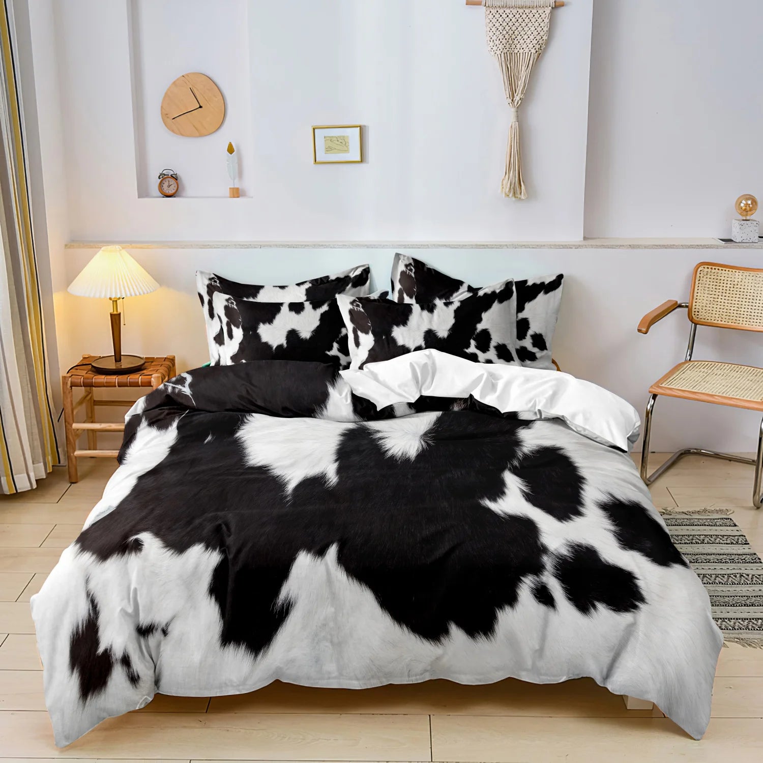 Black and white cow print 3-piece bedding set with matching pillowcases styled on a modern bed