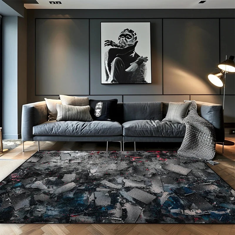 Dark grey, shattered abstract area rug with red and blue paint splatter in a moody modern living room with a grey sofa