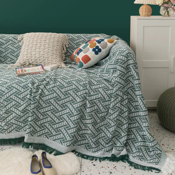 Sage green sofa cover with woven texture in a light, minimalist interior