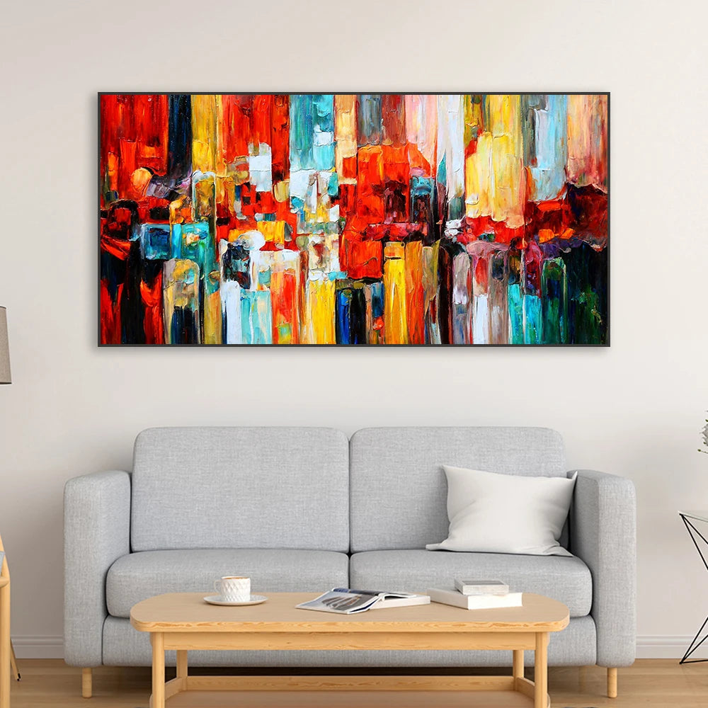 Abstract colourful painting on a wall above a gray sofa in a living room.