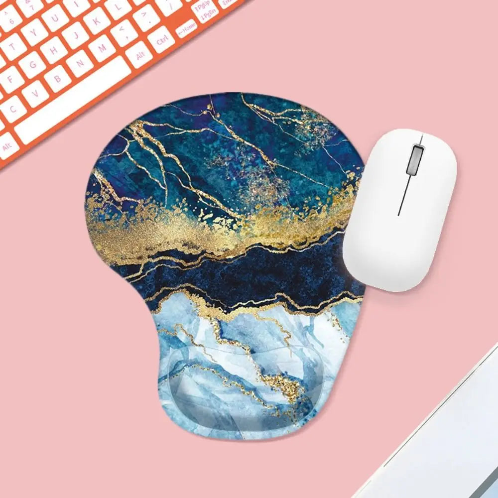 Mouse pad with blue and gold marble design on a pink surface with a keyboard and mouse.