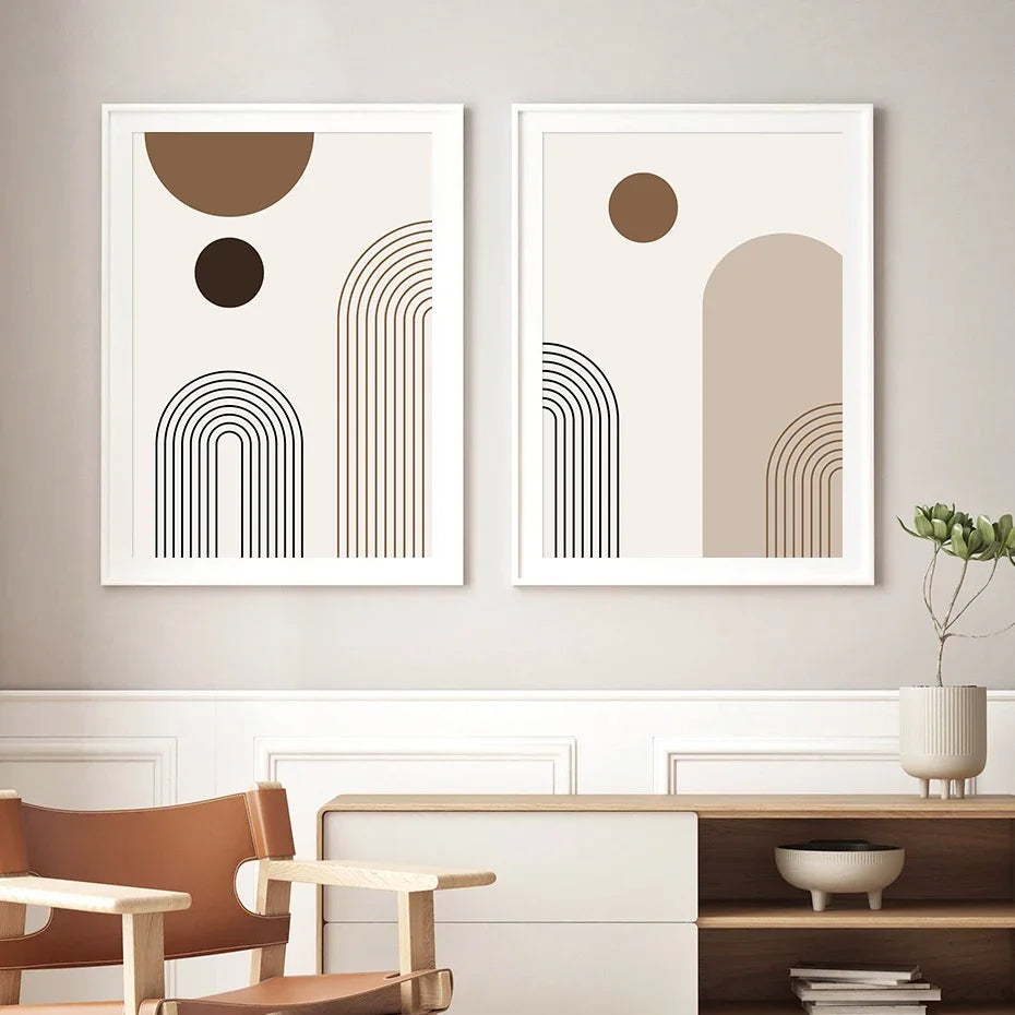 Two abstract art prints on a wall with a chair and shelf in the foreground.