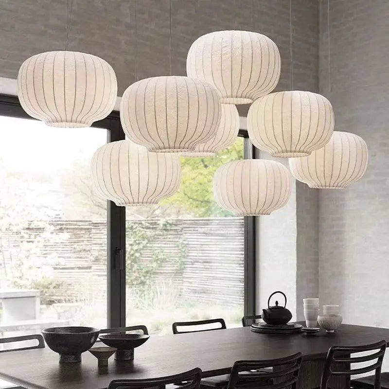 Set of round pendant lights hanging above a dining table with a modern interior design.
