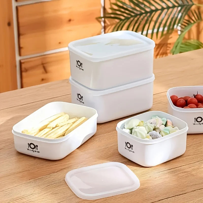 Set of white food storage containers with lids on a wooden surface.