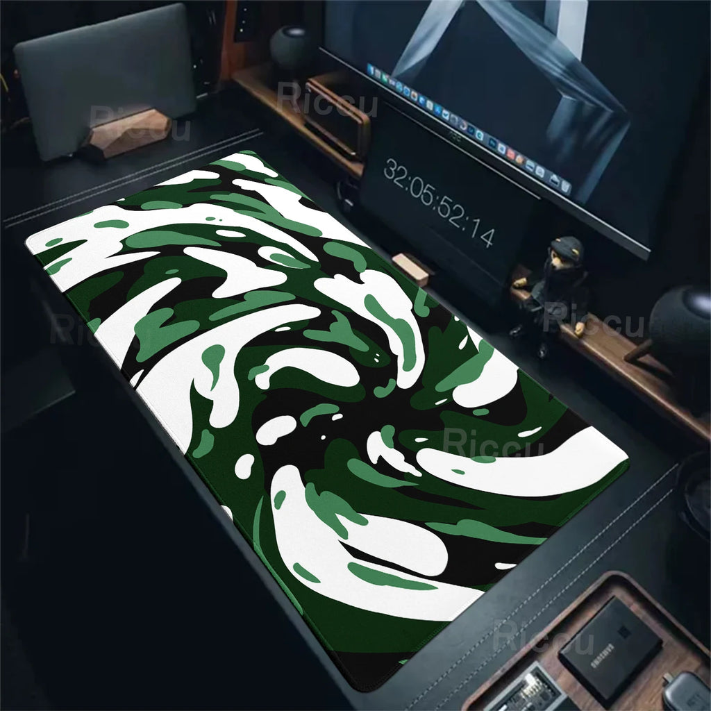 Camouflage-patterned desk mat on a desk with computer equipment.