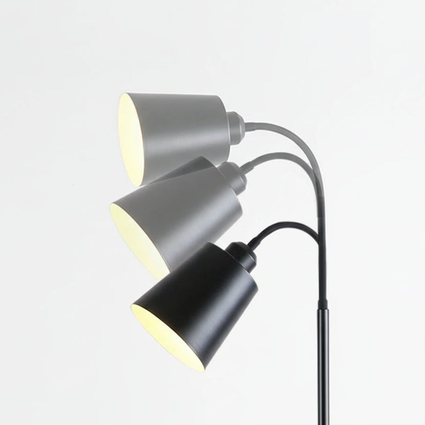 Floor lamp with three adjustable metal lampshades on a light gray background
