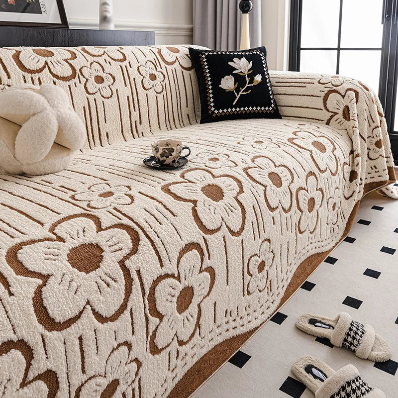 Cream and brown floral sofa throw with raised woven texture, covering a contemporary couch with decorative cushions and soft natural lighting.