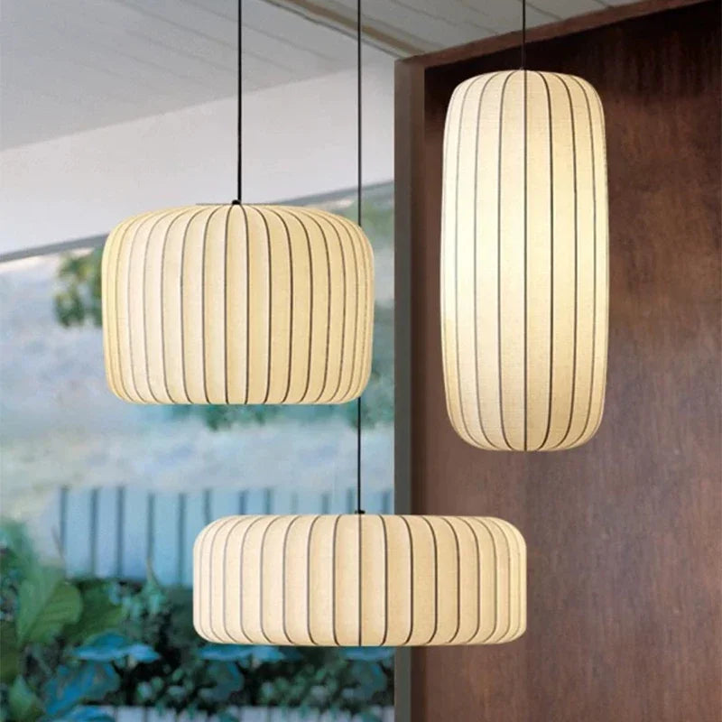 Three pendant lights hanging in a room with a mirror and plants in the background