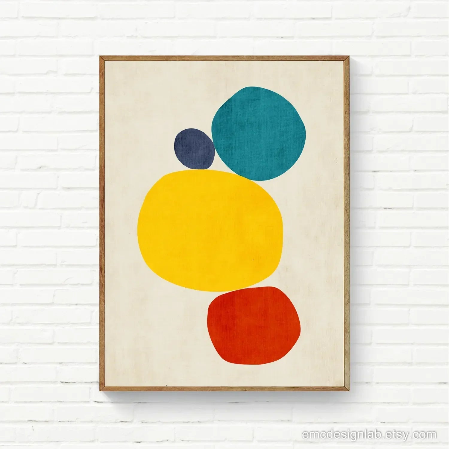 Framed abstract art print with colorful circles on a white brick wall background
