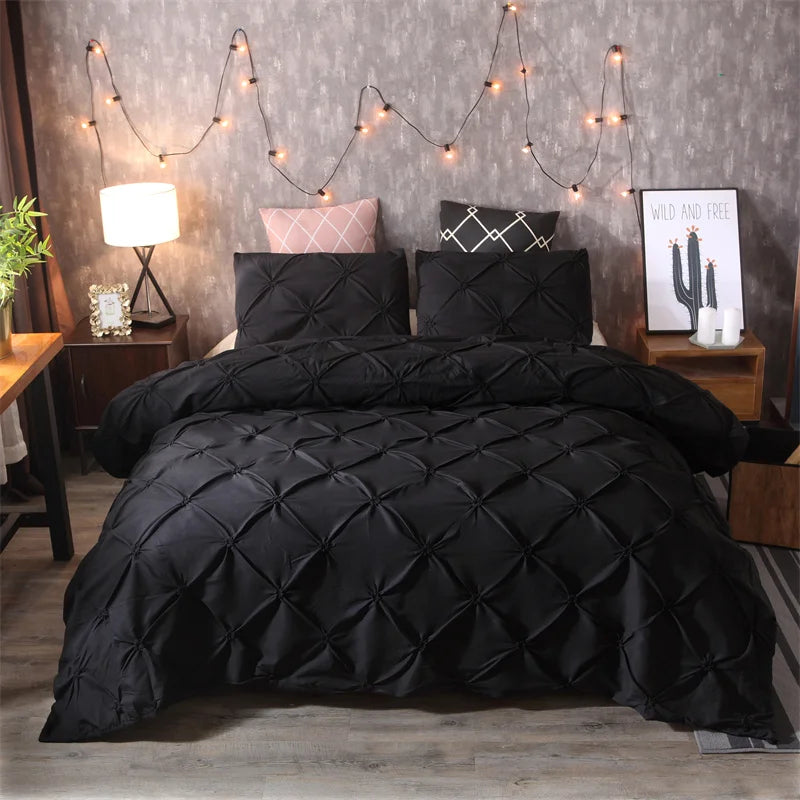 Black pintuck duvet set with matching pillowcases dressed on a double bed in a warm contemporary bedroom