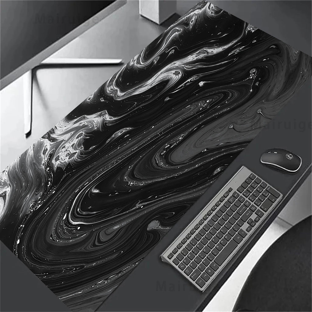 Black and white abstract desk mat with a computer setup on a desk.