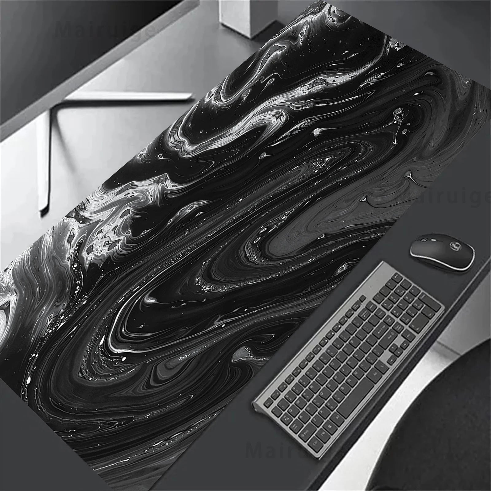 Black and white abstract desk mat with a computer setup on a desk.