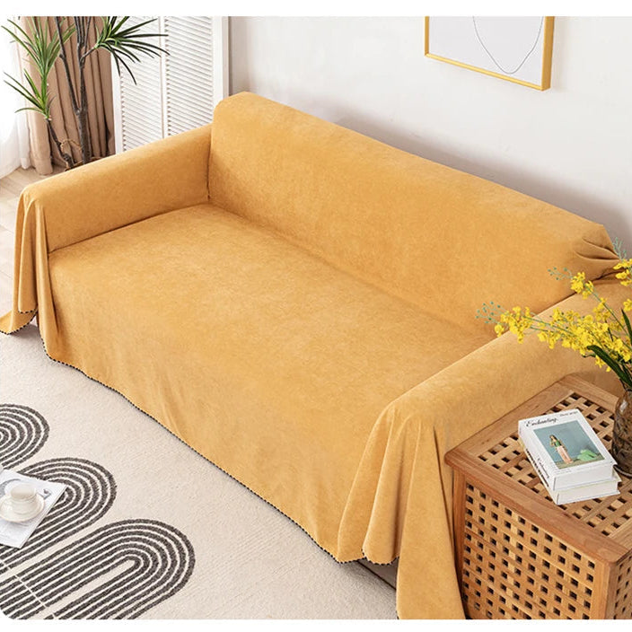 Yellow sofa cover on a couch with a side table and decor elements.