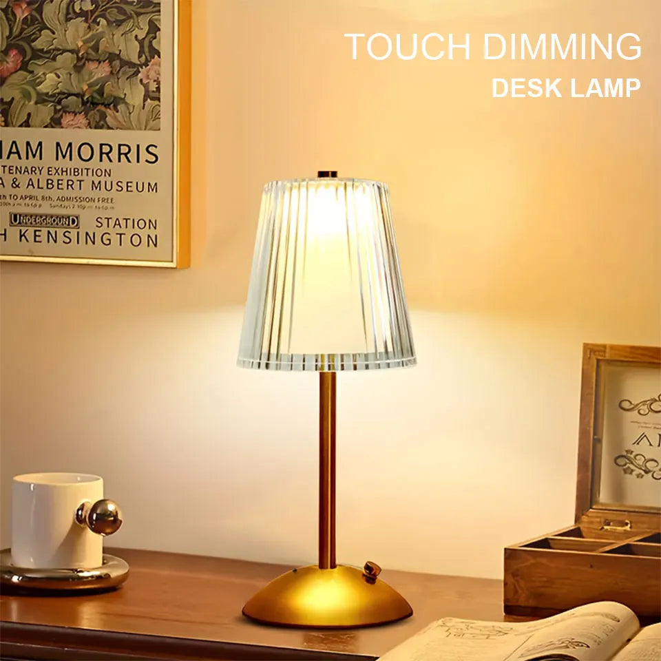 Touch dimming desk lamp on a wooden surface with a cup and book in the background.