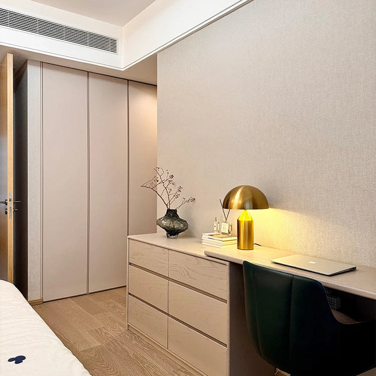 Modern bedroom with a desk, chair, and decorative items.