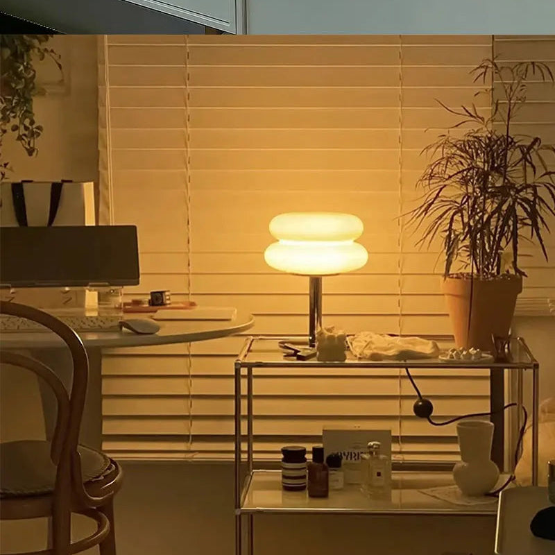 Home office with desk, warm glow table lamp, and window blinds