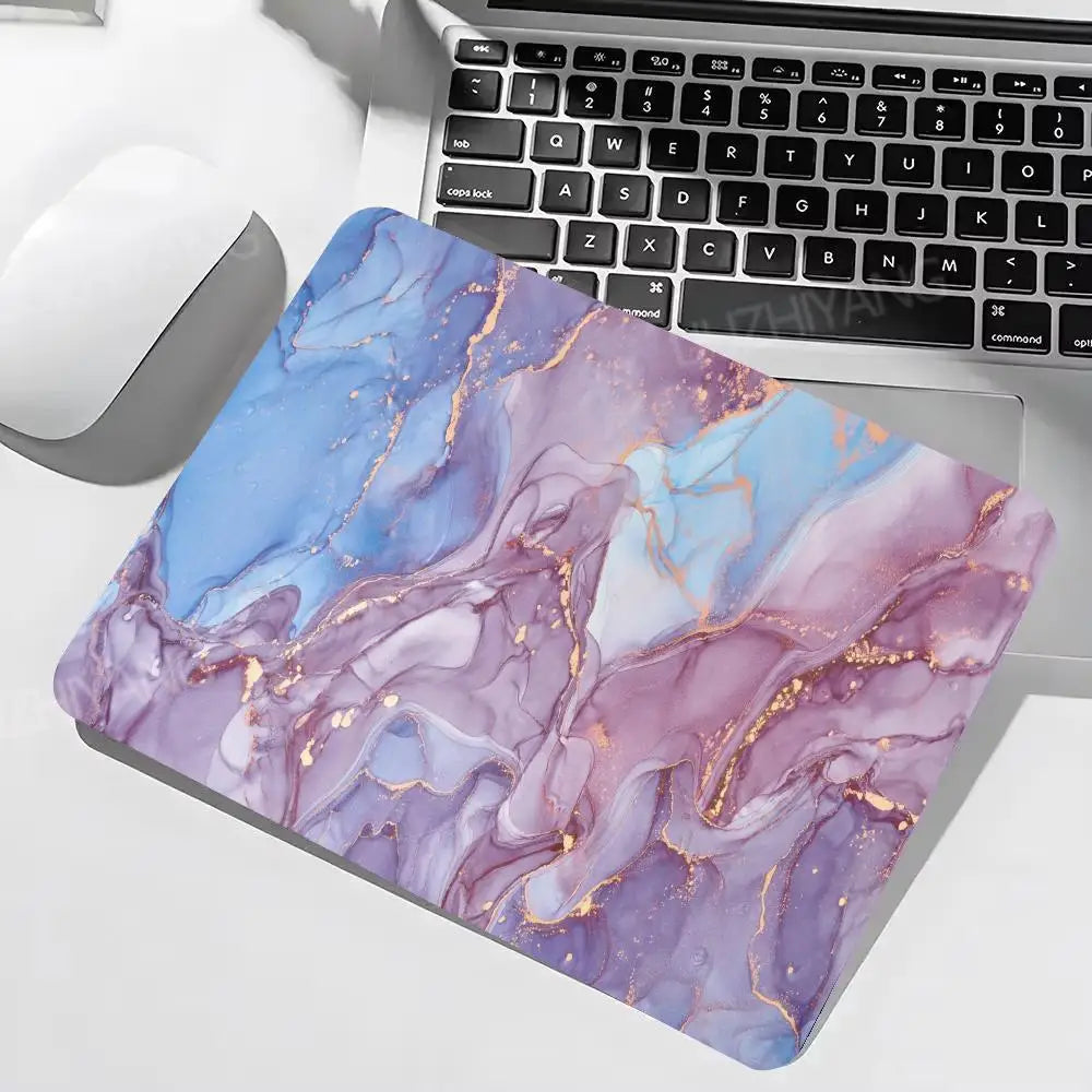Marble-patterned mouse pad on a laptop with keyboard and mouse.
