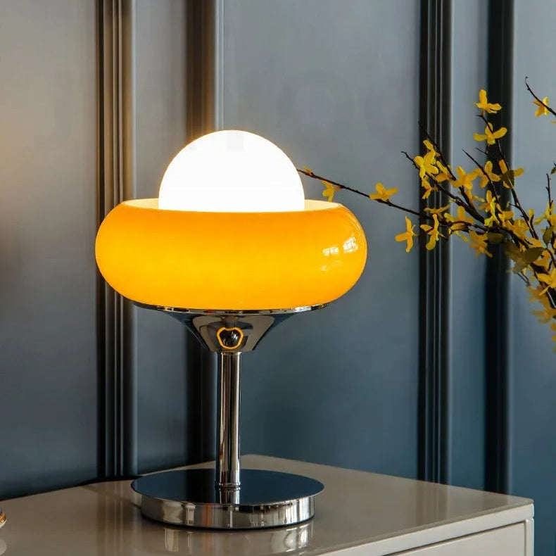 Modern table lamp with a yellow shade on a surface with a blurred background