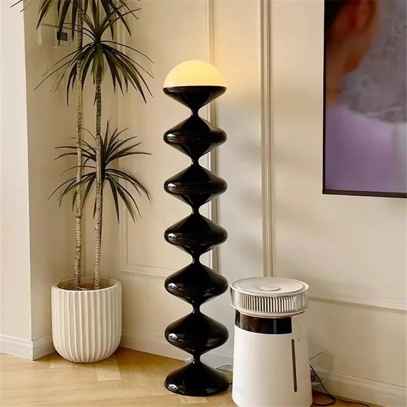 Black sculptural floor lamp with frosted dome shade