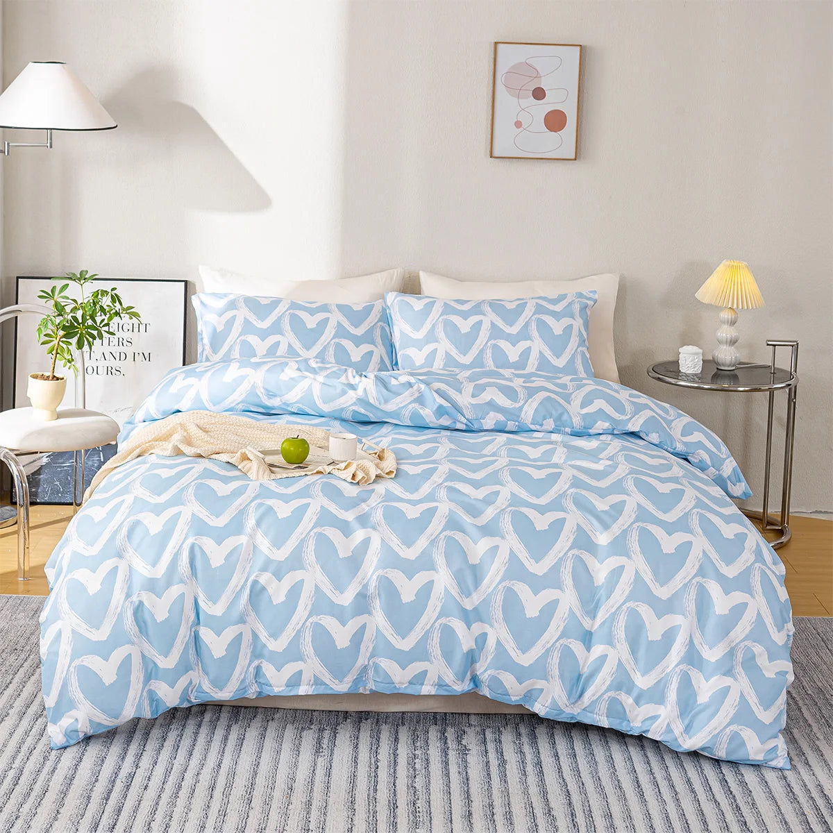 Blue and white heart-patterned bedding set on a bed in a bedroom.
