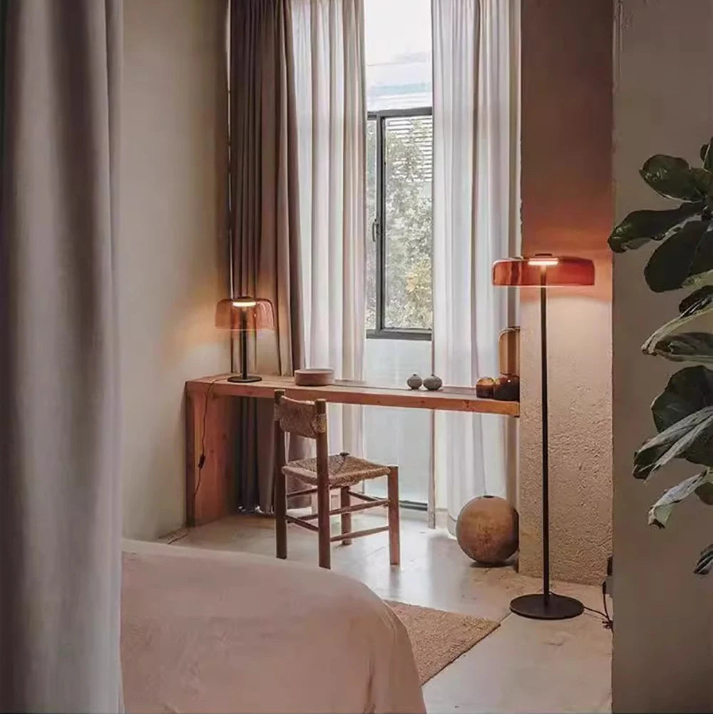 Contemporary floor light with a sunset amber glass shade and sleek gold frame for aesthetic home interiors.