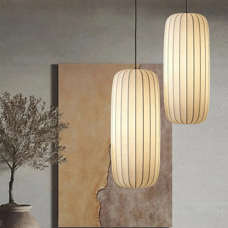 Two pendant lights hanging above a cozy living room setting with a painting and decorative elements.