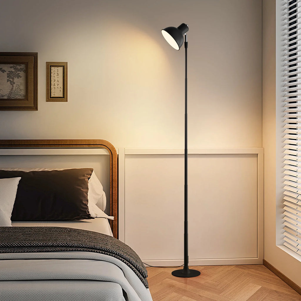 Floor lamp in a bedroom setting with a bed and wall art.
