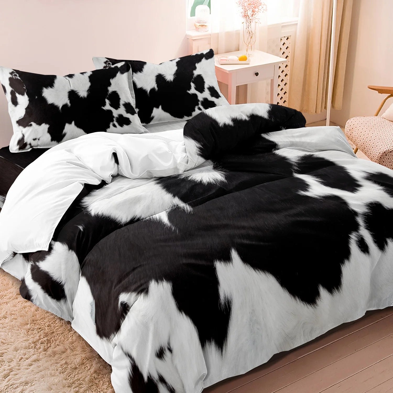 Black and white cow print 3-piece bedding set with matching pillowcases styled on a modern bed