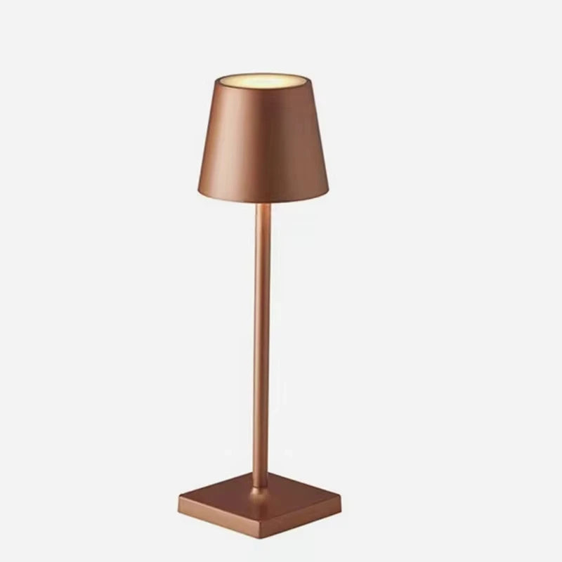 A bronze-coloured table lamp on a white background
