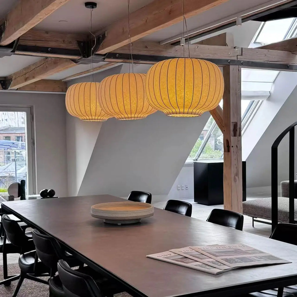 Three Danish-style silk pendant lights hanging above a dining table in a modern interior