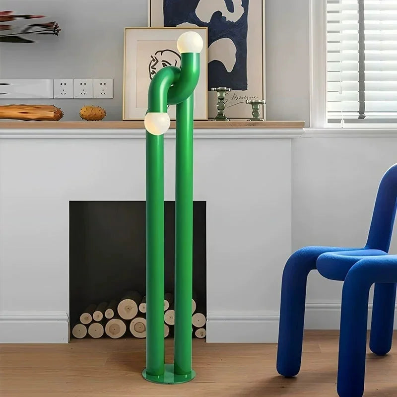 Green floor lamp with round lights in a room with a blue chair and fireplace.