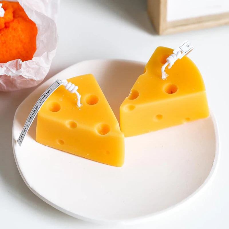 Cheese-shaped candles on a white plate with a white background