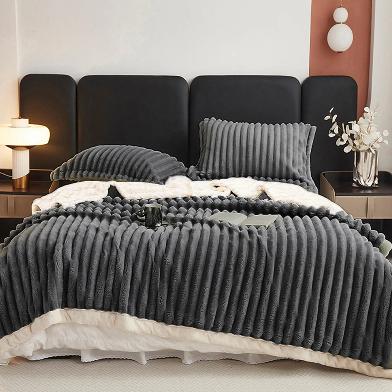 A charcoal grey textured comforter on a bed in a bedroom setting