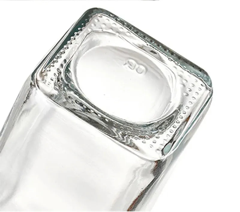 Clear glass base of a bottle on a white background