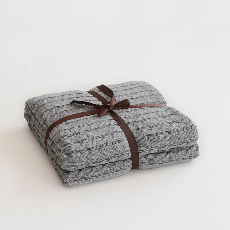 Gray textured blanket tied with a brown ribbon on a white background