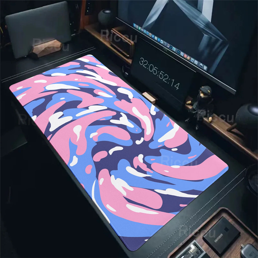 Colorful desk mat on a desk with computer equipment in the background