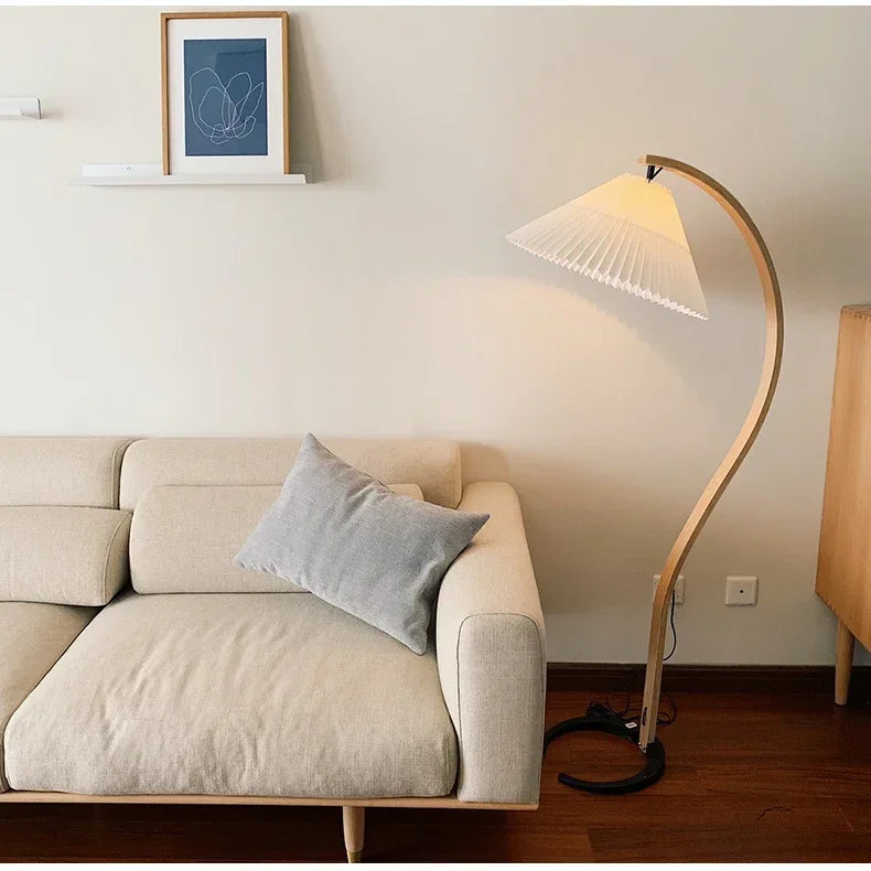 Beige sofa with a gray pillow and a floor lamp in a living room setting.