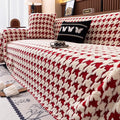 A stylish red and cream houndstooth pattern quilted furniture protector on a large sofa.