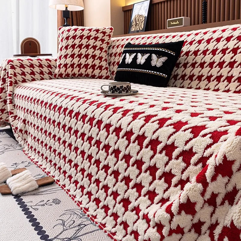 A stylish red and cream houndstooth pattern quilted furniture protector on a large sofa.