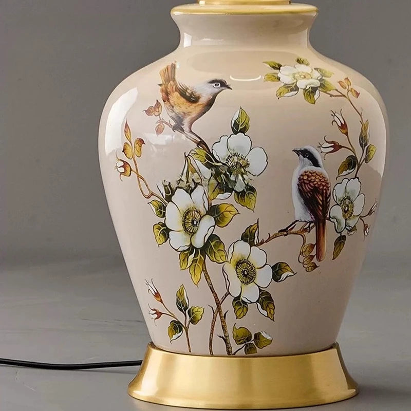 Decorative lamp with bird and floral design on a plain background