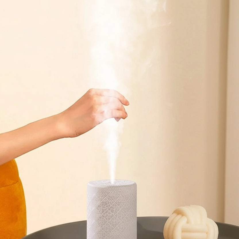 Someone with their hand out over the top of an aromatherapy diffuser