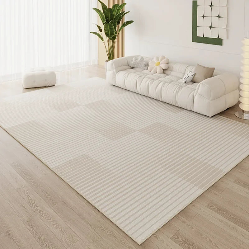 Large cream fine stripe area rug in a bright minimalist living room with white cloud sofa and wooden floor