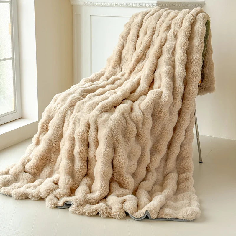 Beige textured blanket draped over a chair in a bright room with a window.