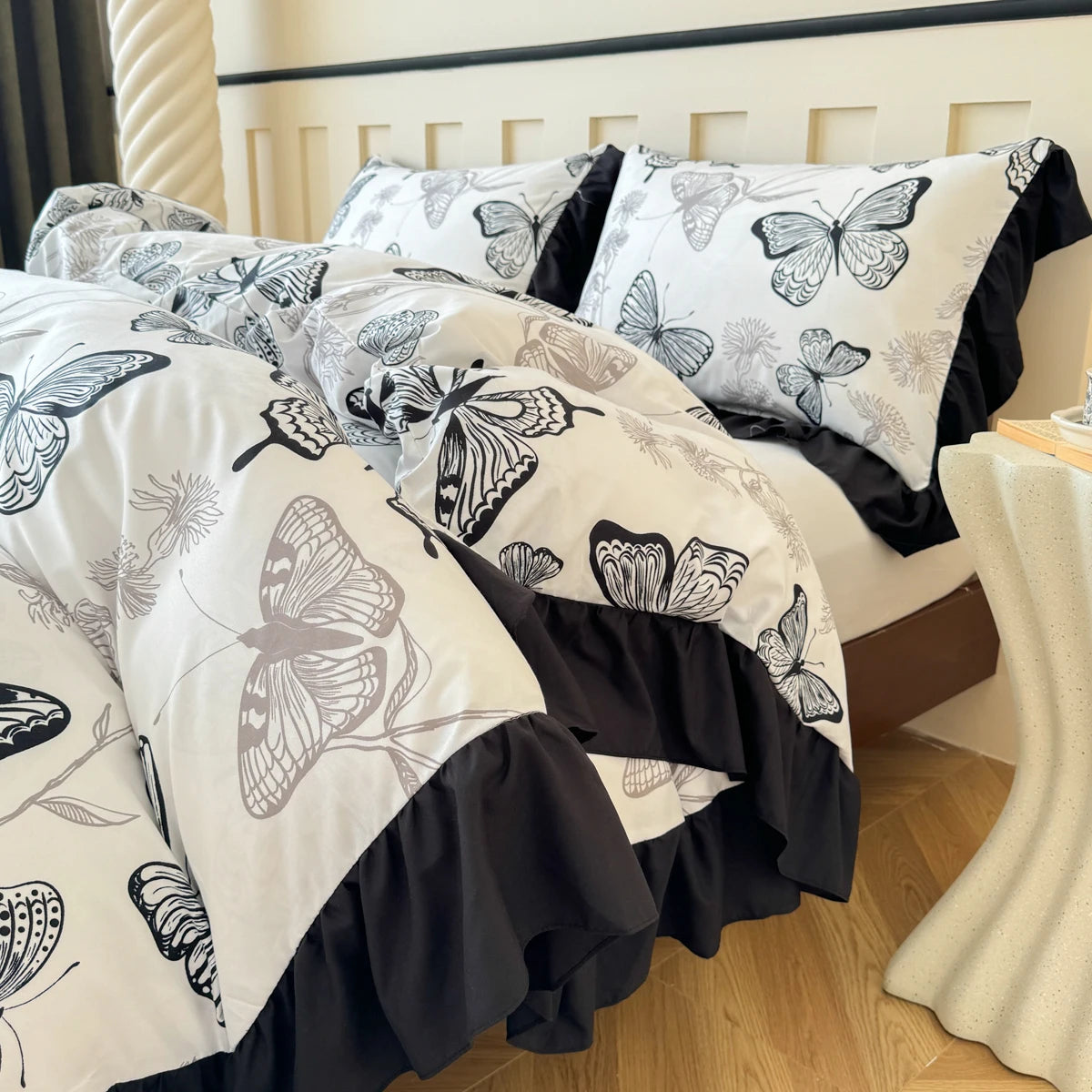 Close-up side profile of the butterfly duvet, highlighting the dramatic black pleated ruffle and the smooth texture of the printed fabric.